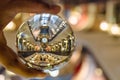 Great Australia Clock in Queen Victoria building photography in clear crystal glass ball with left male hand holding.